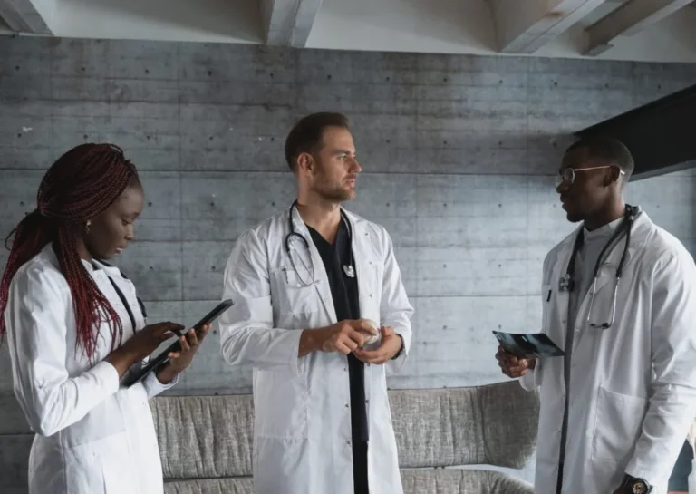 three doctors talking in a room. One female and two males. medication assisted treatment