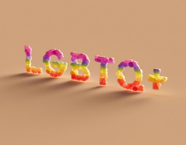 LGBTQ+ letters in rainbow color form with a tan background