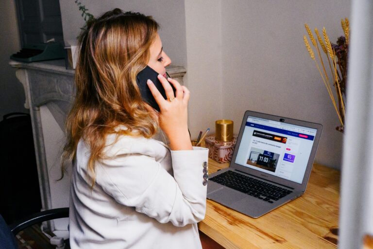 woman sitting at a computer on the phone talking about case management
